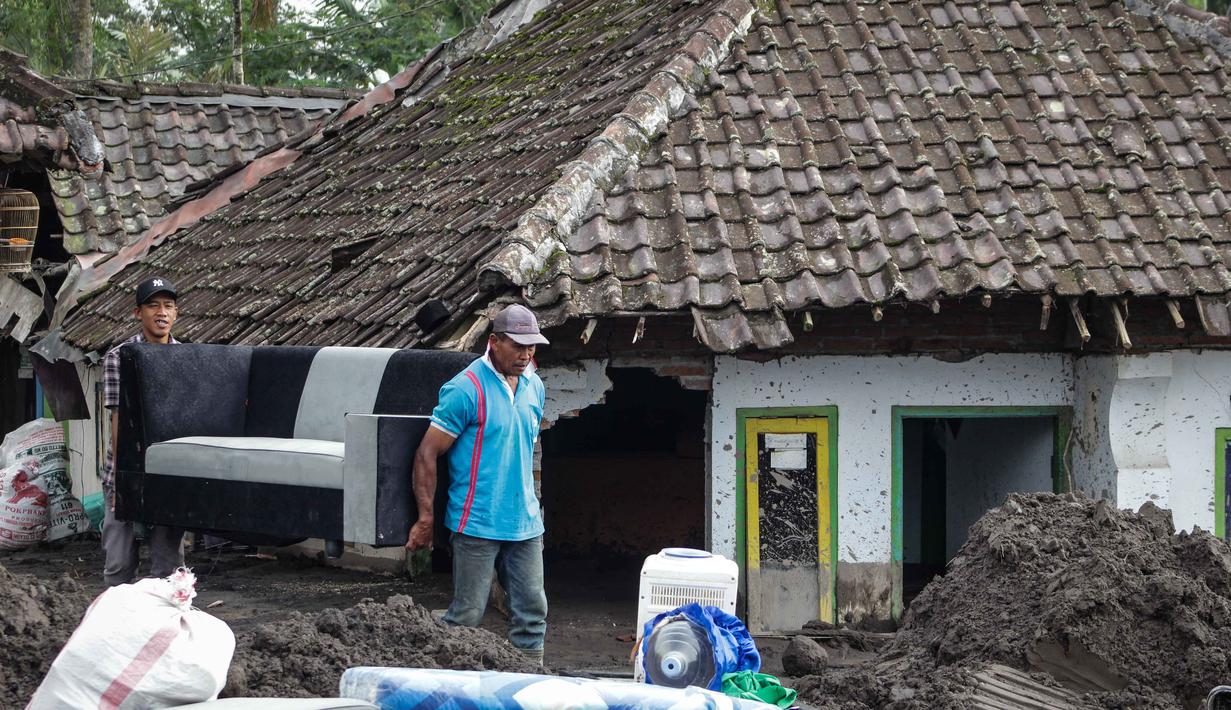 Kerusakan terparah berada di dua dusun di Desa Supiturang, yakni Dusun Gumukmas dan Dusun Sumbersari. Tampak dalam foto, warga menyelamatkan barang-barang dari sebuah rumah yang hancur akibat aliran piroklastik Gunung Semeru di Desa Supiturang, Lumajang, Jawa Timur, pada Jumat 21 November 2025. (Agus Harianto/AFP)
