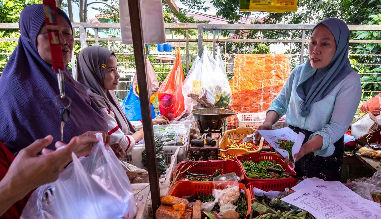 Seorang pedagang menyiapkan pesanan pelanggan di sebuah kios di pasar tradisional di Jakarta pada Rabu 3 Juni 2026. (BAY ISMOYO/AFP)