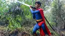 Pelajar bernama Rudiansyah dengan mengenakan kostum Superman membantu memadamkan kebakaran hutan dan lahan di Petuk Katimpun, Palangkaraya, Kalimantan Tengah, 17 Agustus 2026. (AFP/ Reina)