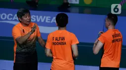 Ganda putra Indonesia, Fajar Alfian/Muhammad Rian Ardianto mendengar instruksi saat melawan pasangan Malaysia, Aarron Chia/Soh Wooi Yik pada final bulutangkis beregu putra SEA Games 2019 di Multinlupa Sport Center, Rabu (4/12/2019). Fajar / Rian kalah 17-21 dan 13-21. (Bola.com/M Iqbal Ichsan)