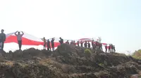 Ada yang beda dari acara yang digelar pemerintah kabupaten setempat, yakni membentangkan bendera raksasa berukuran 150 x 3 meter, di atas Gunung Warung yang terletak di Desa Dalangan, Kecamatan Todanan. (Liputan6.com/Ahmad Adirin)