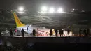 Tim penyelamat dan petugas pemadam kebakaran bekerja setelah sebuah pesawat tergelincir di landasan pacu Bandara Sabiha Gokcen, Istanbul, Turki, Rabu (5/2/2020). Pesawat milik maskapai Pegasus Airlines tersebut keluar dari landasan pacu dan terbelah menjadi tiga bagian. (AP Photo/Emrah Gurel)