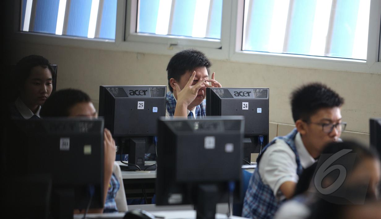 Siswa bersiap mengikuti Ujian Nasional (UN) berbasis komputer atau Computer Based Test (CBT) di SMPK Penabur 2, Jakarta, Senin (4/5). SMPK Penabur 2 menjadi satu-satunya SMP yang melaksanakan UN berbasis komputer di Jakarta. (Liputan6.com/Faizal Fanani)