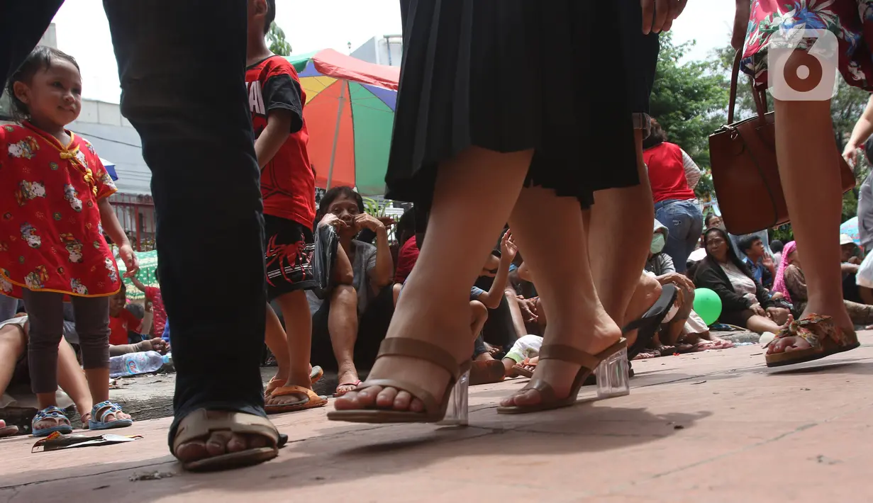 Pengemis menunggu sedekah Imlek di halaman Vihara Dharma Bhakti, Petak Sembilan, Jakarta Barat, Sabtu (25/1/2020). Pembagian sedekah tersebut dalam rangka berbagi dengan sesama ketika perayaaan Tahun Baru Imlek 2571. (Liputan6.com/Angga Yuniar)