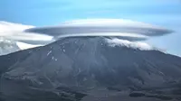 Awan lenticular yang terlihat di Sicily, Italia, terbentuk akibat adanya tiupan uap air melewati puncak gunung dan menetes pada sisi lain (Dailymai.com).