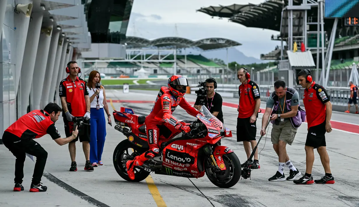 Ducati Lenovo Racer, Marc Marquez (tengah) mendorong sepeda motornya dalam tes MotoGP 2025 pra -musim di Sepang Circuit, Malaysia, Rabu (05/02/2025). (AFP/ Mohd Rasfan)