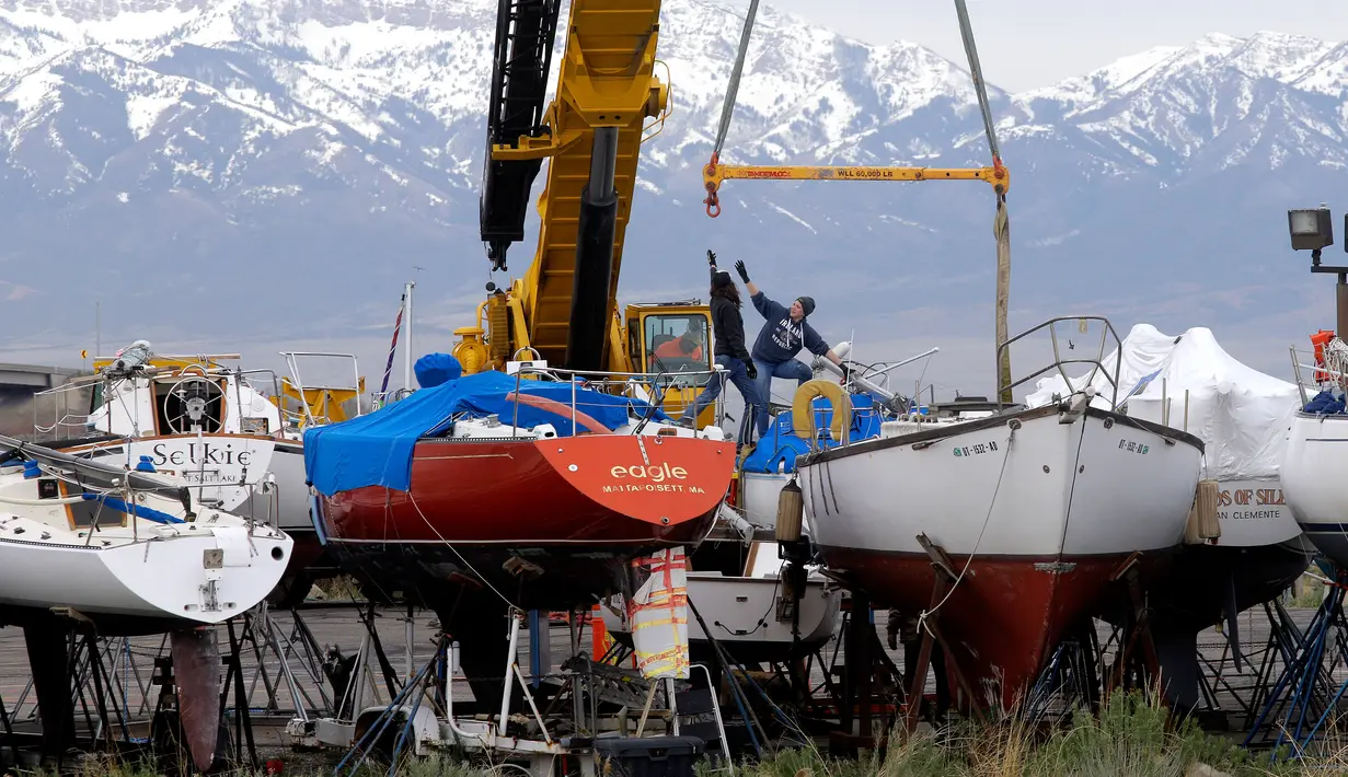 Pekerja menggunakan alat berat memindahkan perahu layar ke Great Salt Lake, Utah (6/4). (AP Photo / Rick Bowmer)