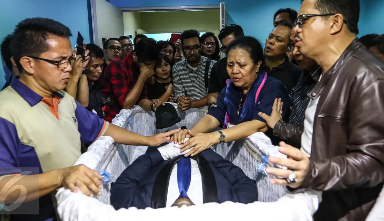Kerabat dan keluarga berdoa di depan jenazah Mike Mohede di dalam peti di RS Bintaro Premiere, Tangsel, Minggu (31/7). Mike Mohede mengembuskan napas terakhirnya saat tidur siang di kamar seusai bermain game. (Liputan6.com/Fery Pradolo)