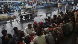 Nelayan berdoa sebelum berbuka puasa selama bulan suci Ramadhan di galangan kapal di kota pelabuhan Karachi, Pakistan pada 18 April 2022. Setelah menjalani ibadah puasa, waktu buka puasa menjadi momen yang dinanti oleh umat Islam. (Rizwan TABASSUM / AFP)