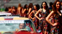 Gadis Grid atau Grid Girls berpose di samping mobil saat parade Grand Prix Formula 1 di Autodromo Hermanos Rodriguez, Meksiko (1/11/2015). Grid Girls akan dihapus saat seri pertama F1 di Melbourne, Australia Maret 2018. (Clive Mason / Getty Images / AFP