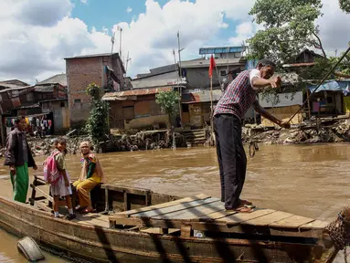 Sejumlah warga menyeberang dengan menggunakan perahu eretan di sungai Ciliwung, Manggarai, Jakarta, Kamis (24/4/14). (Liputan6.com/Faizal Fanani)
