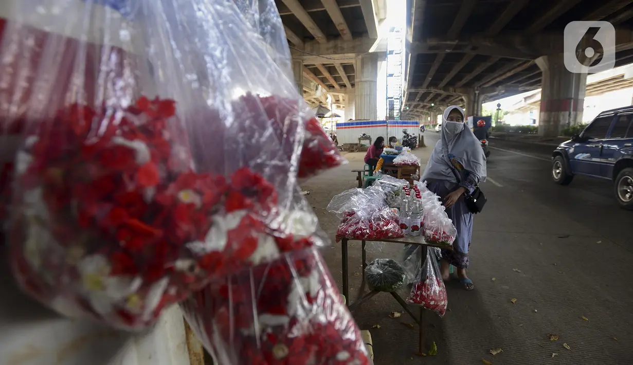 Pedagang berjualan kembang untuk berziarah di kawasan Gembrong, Prumpung, Jakarta, Kamis (23/4/2020). Jelang Ramadan, pedagang kembang untuk berziarah mengeluhkan sepinya pembeli karena adanya Pembatasan Sosial Berskala Besar (PSBB) untuk mencegah penyebaran COVID-19. (merdeka.com/Imam Buhori)