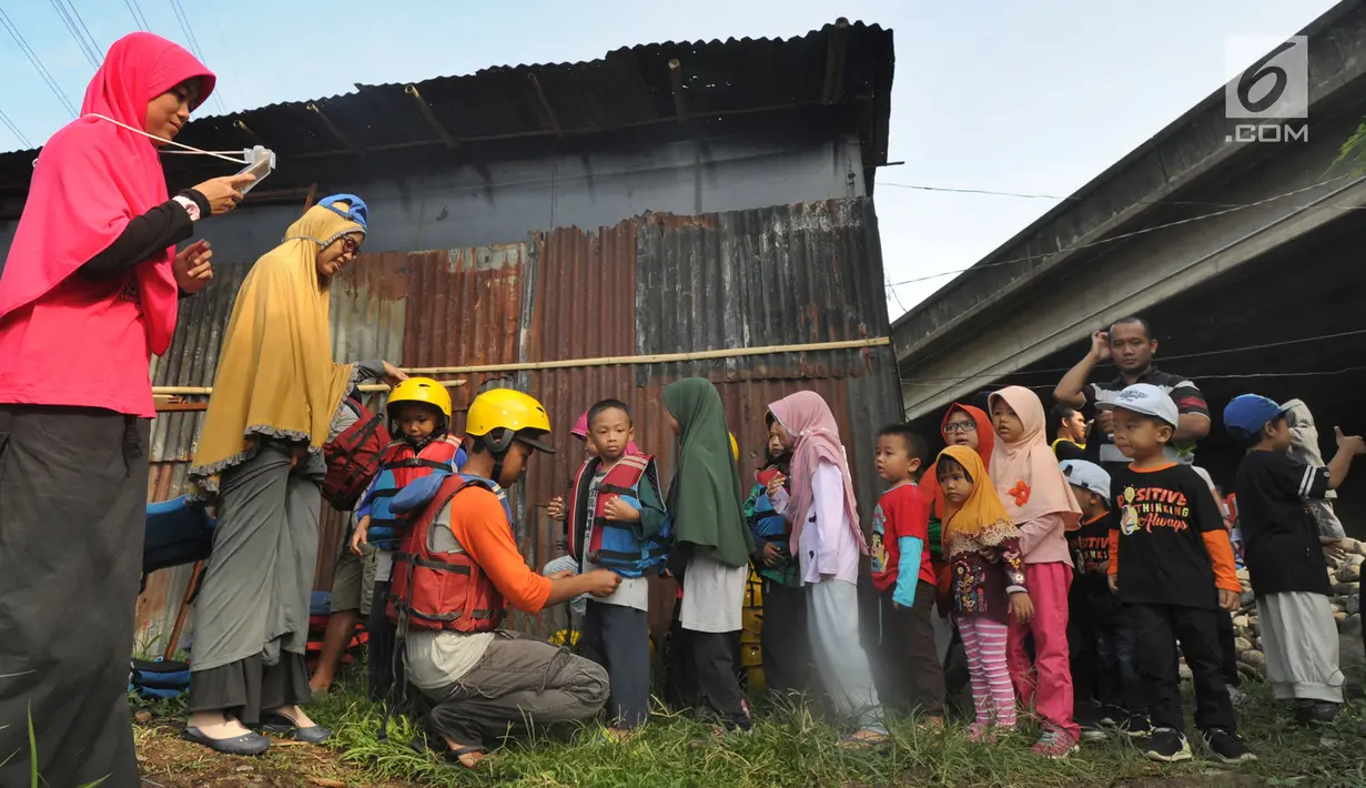 Murid TPQ Kelopak Kalisari Jakarta memakai pelampung sebelum wisata rafting khusus anak di Bendungan Katulampa, Bogor, selasa (20/11). Rafting di aliran Sungai Ciliwung ini diadakan Hiking Bocah melibatkan masyarakat lokal. (Merdeka.com/Arie Basuki)
