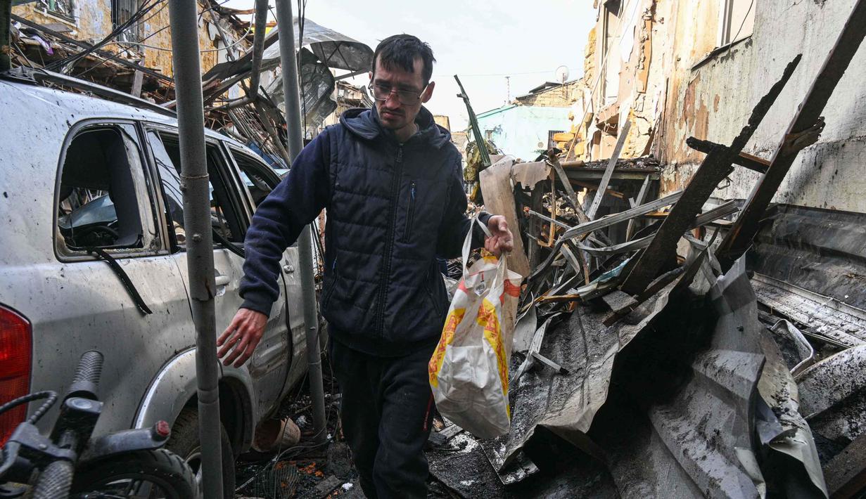 Rusia secara rutin menyerang infrastruktur sipil dan energi Ukraina, termasuk bangunan tempat tinggal, seiring dengan terus berlanjutnya perang yang dilancarkan. Tampak dalam foto, seorang pria berjalan di halaman sebuah lingkungan perumahan yang rusak parah akibat serangan Rusia di Odesa, Ukraina, Jumat 24 April 2026. (AP Photo/Michael Shtekel)