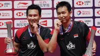 Pasangan ganda putra Mohammad Ahsan/Hendra Setiawan berpose dengan trofi dan medali seusai mengalahkan Hiroyuki Endo/Yuta Watanabe dari Jepang pada final BWF World Tour Finals 2019 di Tianhe Gymnasium, Guangzhou, China (15/12/2019). Ahsan/Hendra menang  24-22, 21-19.  (AP Photo/Andy Wong)