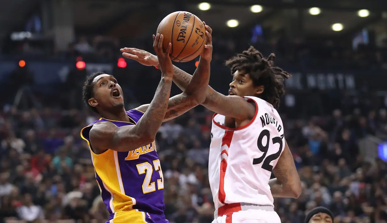 Pemain Los Angeles Lakers, Lou Williams #23 mencoba melakukan tembakan saat dihadang pemain Toronto Raptors pada laga NBA di Air Canada Centre, (2/12/2016). Raptors Menang 113-80. (Reuters/Tom Szczerbowski-USA TODAY Sports)