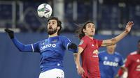 Gelandang Everton, Andre Gomes (kiri), berebut bola dengan striker Manchester United, Edinson Cavani, dalam laga perempatfinal Piala Liga Inggris Carabao Cup di Goodison park, Rabu (23/12/2020). Everton kalah 0-2 dari Manchester United. (AP/Nick Potts/Pool)