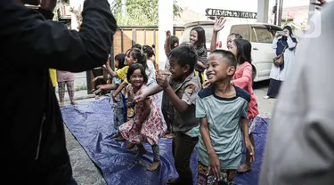 Badan Penanggulangan Bencana Daerah (BPBD) Provinsi DKI Jakarta memberikan bantuan layanan dukungan psikososial kepada anak-anak anak penyintas kebakaran Manggarai di Jalan Manggarai Utara 2, RT 01/01, Kelurahan Manggarai, Tebet, Minggu (17/12/2023). (Liputan6.com/Faizal Fanani)