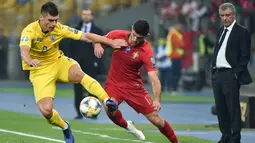 Gelandang Ukraina, Ruslan Malinovskyi berebut bola dengan striker Portugal, Goncalo Guedes selama pertandingan Grup B Kualifikasi Piala Eropa 2020 di Stadion NSK Olympiyskiy (15/10/2019). Dengan kemenangan ini, Ukraina lolos ke putaran final Piala Eropa 2020 dari grup B. (AFP Photo/Genya Savilov)