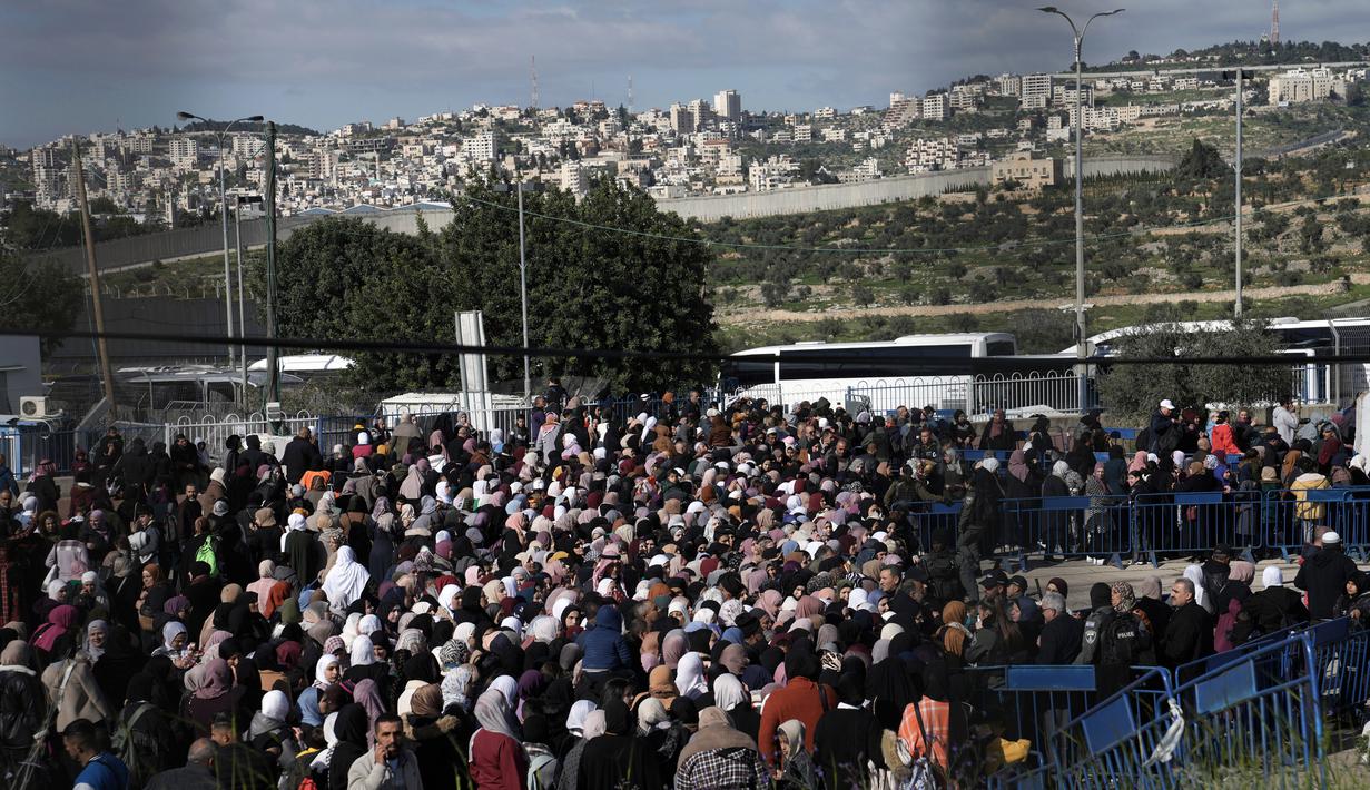 <p>Warga Palestina mengantre bus setelah menyeberang dari Kota Bethlehem di Tepi Barat ke Yerusalem untuk mengikuti sholat Jumat di Kompleks Masjid Al Aqsa selama bulan suci Ramadhan, Jumat (31/3/2023). (AP Photo/Mahmoud Illean)</p>