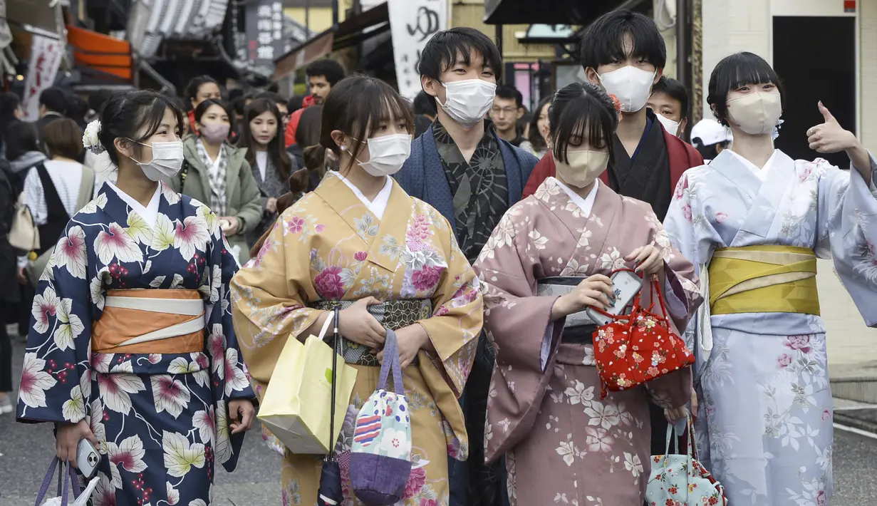 Sejumlah perempuan berpakaian tradisional kimono berjalan di sepanjang tujuan wisata di Kyoto, Jepang barat, Senin (13/3/2023). Meski aturan penggunaan masker telah dilonggarkan,  banyak orang di tempat-tempat umum dan tempat berkumpul yang masih menggunakan masker. (Kyodo News via AP)