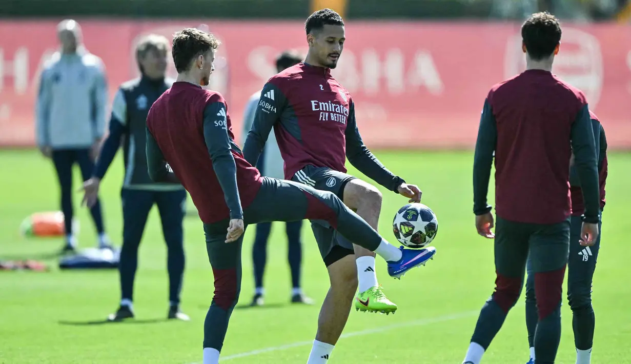 Duel Sporting CP dan Arsenal akan digelar di Estadio Jose Alvalade, Lisbon, Portugal, Rabu (8/4/2026) dini hari WIB. Tampak dalam foto, bek Arsenal asal Inggris, Ben White (kiri) dan William Saliba (tengah) saat mengikuti sesi latihan tim di pusat pelatihan Arsenal di London Colney, utara London, pada Senin 6 April 2026. (Glyn KIRK/AFP)