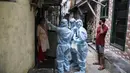 Petugas kesehatan India yang mengenakan alat pelindung diri melakukan pemeriksaan COVID-19 di kawasaan permukiman kumuh di tengah penyebaran wabah tersebut di Mumbai, India (17/6/2020). (Xinhua/Stringer)