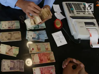 Karyawan memeriksa uang kertas rupiah yang rusak di tempat penukaran uang rusak di Gedung Bank Indonessia, Jakarta (4/4). Bank Indonesia memfasilitasi masyarakat untuk menukarkan uang rupiah yang rusak secara gratis. (Merdeka.com/Arie Basuki)