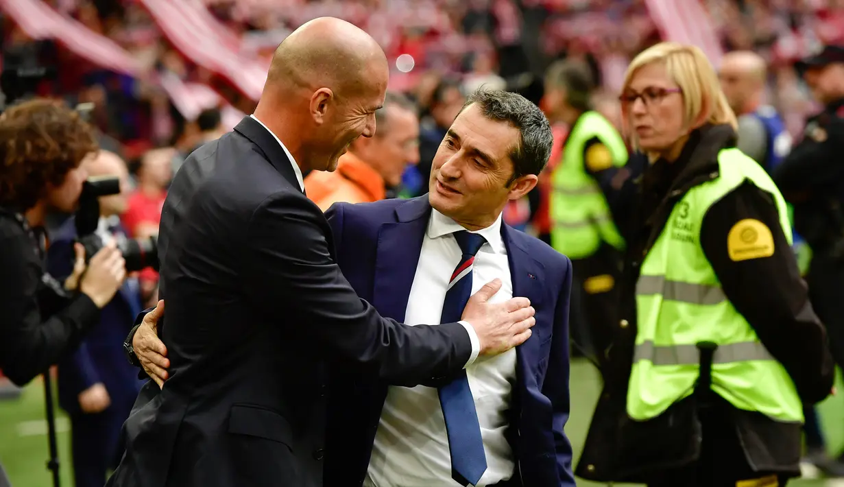 Ernesto Valverde berbincang dengan pelatih Real Madrid, Zinedine Zidane sebelum pertandingan Real Madrid melawan Athletic Bilbao pada 18 Maret 2017. Valverde menggantikan posisi Luis Enrique, yang mundur di akhir musim. (AP Photo/Alvaro Barrientos, File)