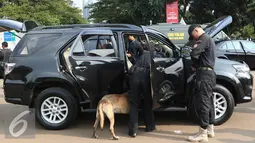 Petugas dan anjing pelacak mengecek bagian dalam mobil yang akan digunakan dalam WIEF ke-12 di Jakarta, Senin (1/8). WIEF ke-12 akan berlangsung di Jakarta pada 2-4 Agustus 2016. (Liputan6.com/Immanuel Antonius)