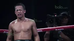 Pelipis Daud Yordan pecah akibat benturan dengan kepala Yoshitaka Kato dan pertandingan terpaksa dihentikan wasit di ronde 9. Daud Yordan berhasil mempertahankan gelar WBO Asia Pasifik dan Afrika dengan kemenangan angka. (Bola.com/Vitalis Yogi Trisna)