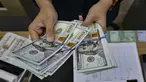 Seorang menghitung uang kertas Dolar AS di salah satu kantor penukaran uang, Jakarta, Selasa 12 Mei 2026. Nilai tukar rupiah terhadap dolar Amerika Serikat (USD) terpuruk pada perdagangan Selasa (12/5/2026). (BAY ISMOYO/AFP)