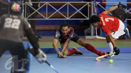 Pemain hoki DKI Jakarta, Daarul Quthni (tengah) berebut bola dengan pemain Jawa Barat saat laga final hoki putra PON XIX Jabar di Gymnasium UPI, Bandung, Senin (19/9). Jawa Barat menundukkan DKI Jakarta dengan skor 3-1. (Liputan6.com/Helmi Fithriansyah)