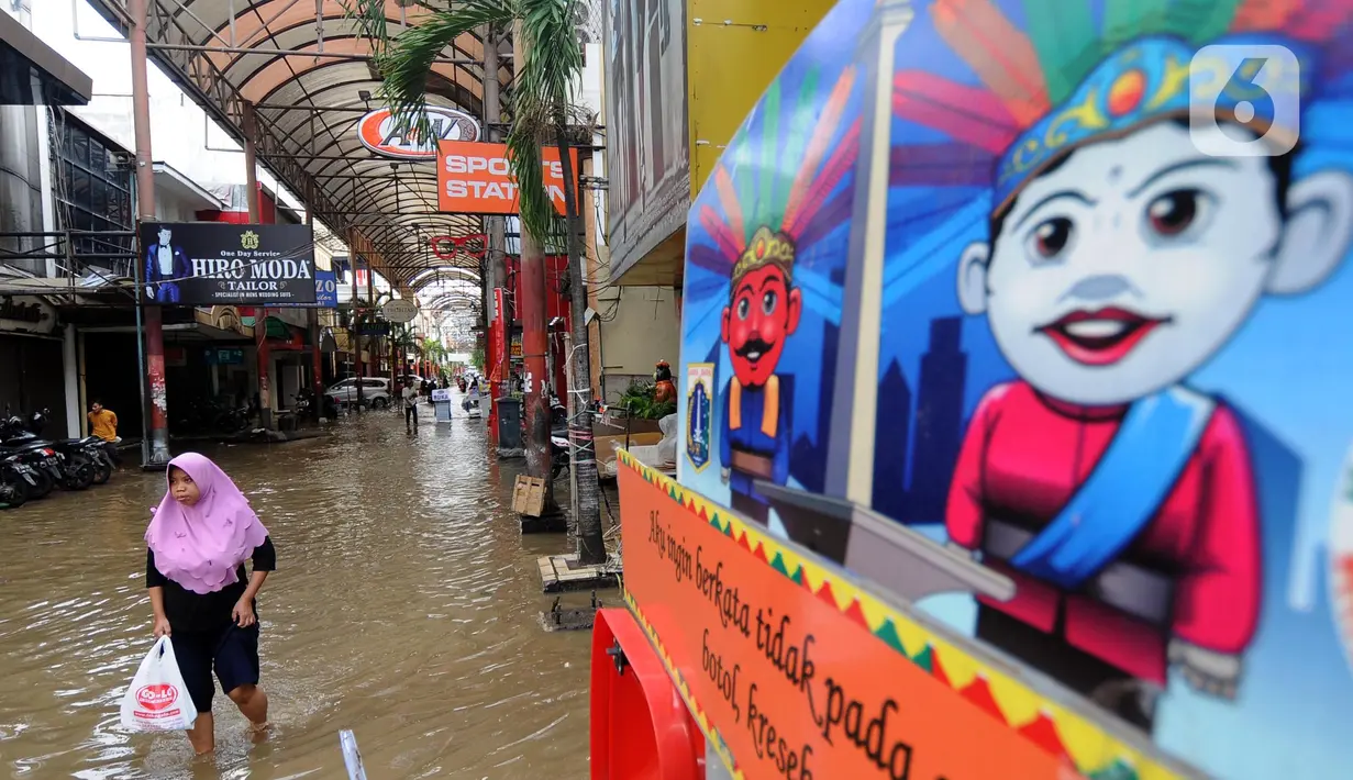 Warga melintas di kawasan pertokoan Pasar Baru, Jakarta, Kamis (2/1/2020). Pasca banjir yang melanda sejumlah titik di Jakarta pada Rabu (1/1), aktivitas perniagaan di kawasan Pasar Baru masih terlihat sepi dan sebagian toko masih tutup. (Liputan6.com/Helmi Fithriansyah)