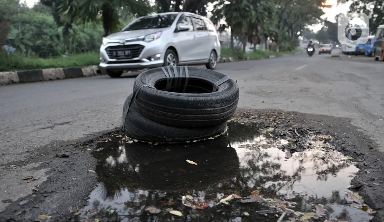 Ban bekas untuk menutupi jalan berlubang di Jalan Tegar Beriman, Cibinong, Bogor, Minggu (31/5/2020). Sudah berbulan-bulan akses yang dikenal sebagai jalan Pemda Cibinong ini sangat memprihatinkan hingga sering menyebabkan kecelakaan terlebih saat musim hujan. (merdeka.com/Iqbal Nugroho)