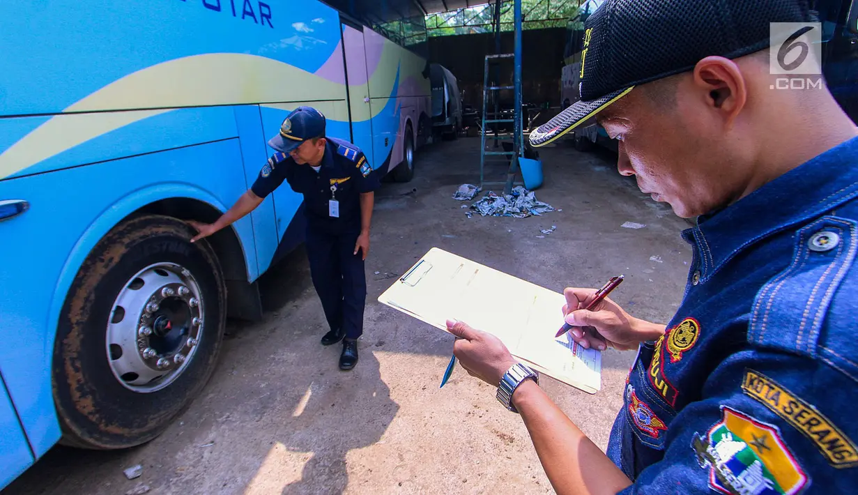 Petugas BPTD wilayah Banten Kementerian Perhubungan mengecek bagian ban bus di Pool Blue Star, Pondok Cabe, Rabu (30/5). (Merdeka.com/Arie Basuki)