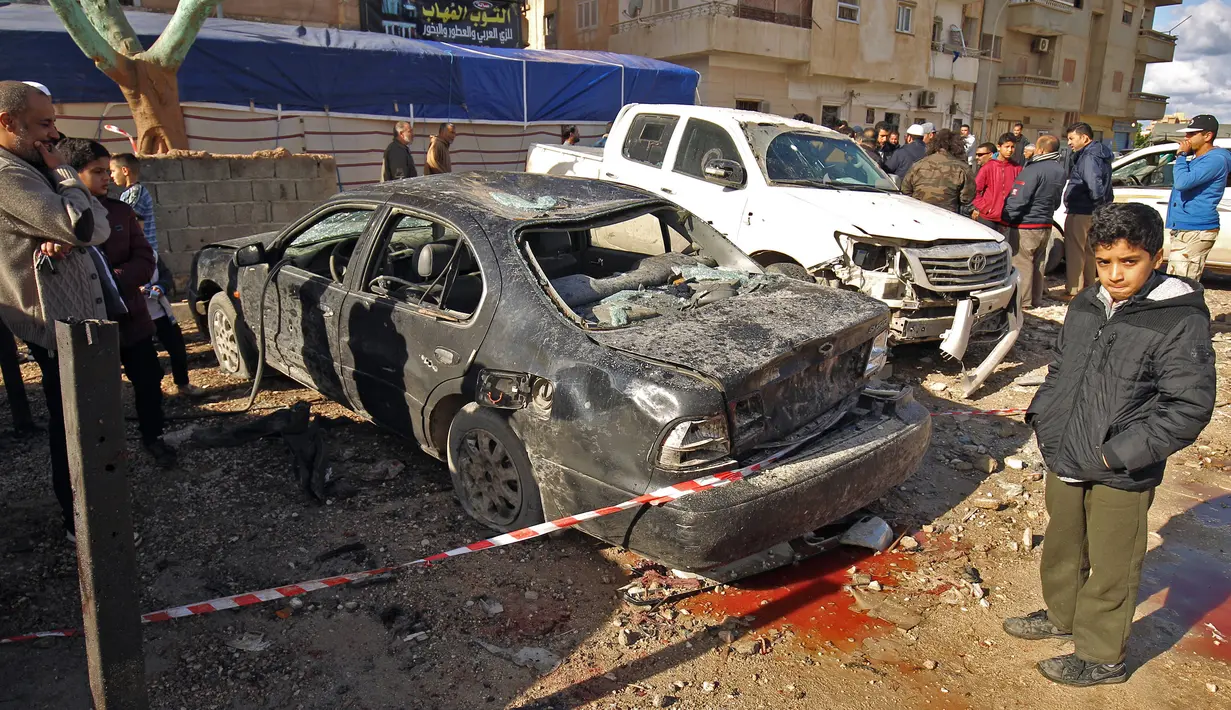 Warga melihat-lihat dampak kerusakan akibat serangan bom mobil ganda di Kota Benghazi, Libya, Rabu (24/1). Korban dari kedua peristiwa itu meliputi personel militer dan warga sipil. (AFP PHOTO/Abdullah DOMA)