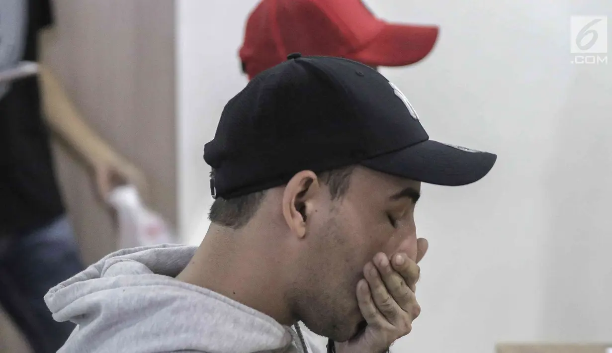 Aktor Riza Shahab mengusap wajahnya saat menjalani pemeriksaan di Polda Metro Jaya, Jakarta, Jumat (13/4). Riza ditangkap bersama Reza Alatas di apartemen kawasan Kuningan. (Liputan6.com/Faizal Fanani)