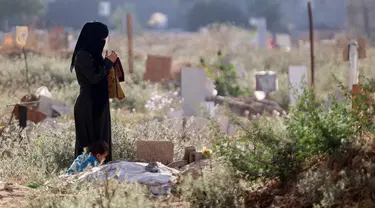 Seorang wanita Palestina berdoa di dekat makam seorang kerabatnya yang menjadi korban dalam konflik yang sedang berlangsung antara Israel dan milisi Hamas, di sebuah pemakaman darurat di lingkungan al-Tuffah timur Kota Gaza, pada 16 Juni 2024. (Omar AL-QATTAA/AFP)