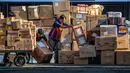 Selain dipadati calon penumpang, baik jarak jauh maupun dekat, Stasiun Lempuyangan, Yogyakarta, juga kedatangan sejumlah paket barang dan motor. Tampak dalam foto, Para pekerja mengatur paket-paket setelah menurunkannya dari gerbong barang kereta api di stasiun kereta api Lempuyangan, Yogyakarta pada 14 Maret 2026. (DEVI RAHMAN/AFP)