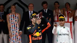 Pembalap Red Bull Daniel Ricciardo meminum sampanye dari sepatu saat merayakan kemenangannya di balapan Grand Prix Monaco Formula 1, Monaco (27/5). Ricciardo hingga kini mengumpulkan nilai 47, terpaut 46 poin dari Lewis Hamilton. (AP/Luca Bruno)