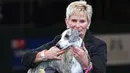Yvette Short berpose dengan "Collooney Tartan Tease" (Tease), the Whippet, pemenang kompetisi Best in Show pada hari terakhir Crufts dog show 2018 di National Exhibition Centre di Birmingham, Inggris (11/3). (AFP Photo/Oli Scarff)