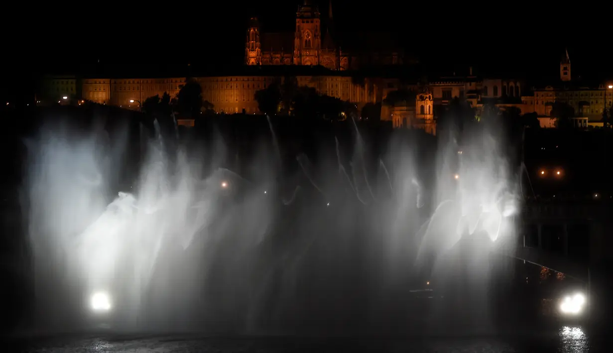 Pemandangan indah saat semprotan air pemadam kebakaran berhias cahaya di atas Sungai Vltava untuk menandai HUT ke-100 Ceko di Praha, Sabtu (2/6). (Michal Cizek/AFP)