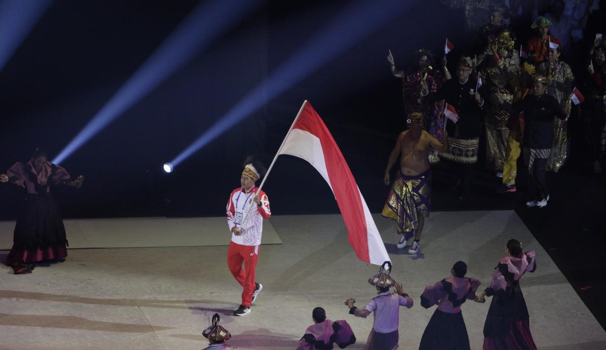 Atlet polo air, Ridjkie Mulia, membawa bendera saat kontingen Indonesia melintas pada upacara pembukaan SEA Games 2019 di Philipine Arena Bulacan, Manila, Sabtu (30/11). Pesta olahraga se-Asia Tenggara ini akan berlangsung hingga 11 Desember. (Bola.com/M