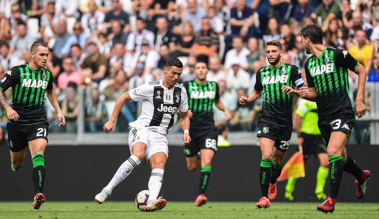 Striker Juventus, Cristiano Ronaldo, berusaha melewati kepungan pemain Sassuolo pada laga Serie A di Stadion Juventus, Turin, Minggu (16/9/2018). CR 7 cetak dua gol, Juve menang 2-0 atas Sassuolo. (AFP/Miguel Medina)