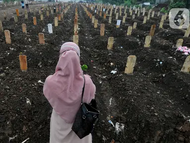 Keluarga berdoa depan pusara makam korban Covid-19 di TPU Srengseng Sawah 2, Jakarta Selatan, Jumat (19/3/2021). Seminggu terakhir intensitas pemakaman korban Covid-19 menurun drastis sebesar rata-rata 20 jenazah/minggu dibandingkan sebelumnya rata-rata 35 jenazah/minggu. (merdeka.com/Arie Basuki)