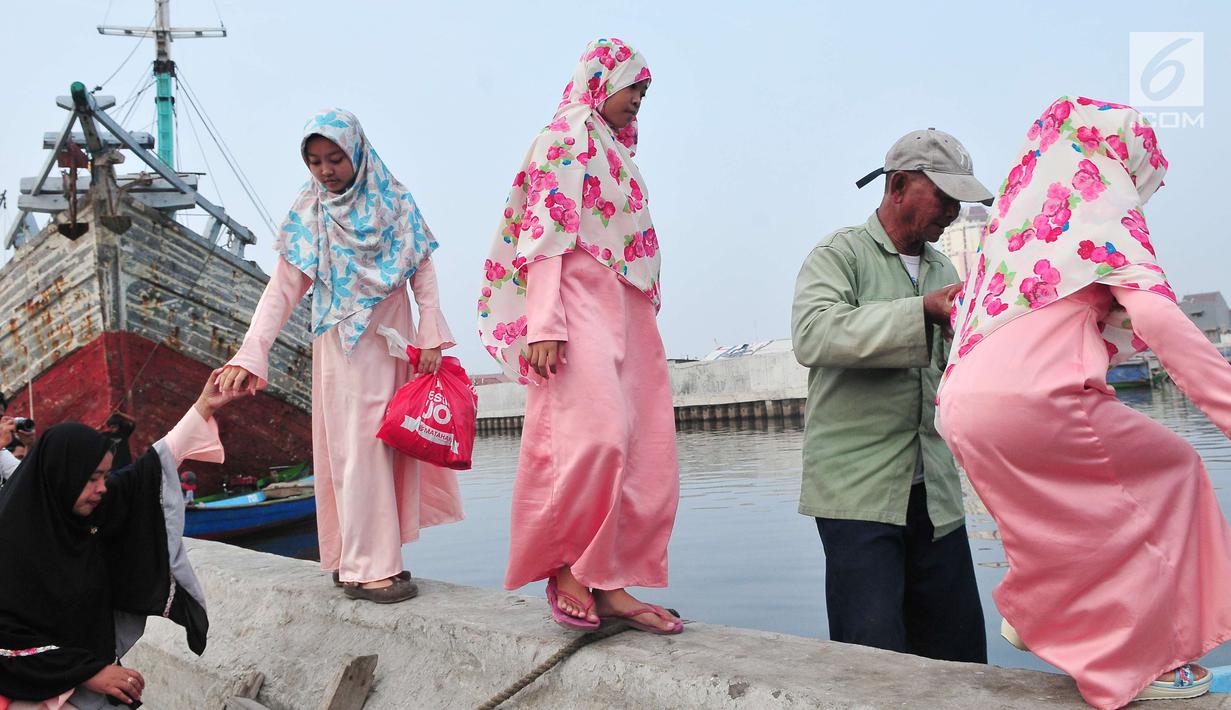 Umat muslim menaiki perahu usai menjalankan Salat Idul Adha 1438 H di kawasan Pelabuhan Sunda Kelapa, Jakarta, Jumat (1/9). Setelah menjalankan salat, umat muslim melakukan penyembelihan hewan kurban. (Liputan6.com/Helmi Afandi)