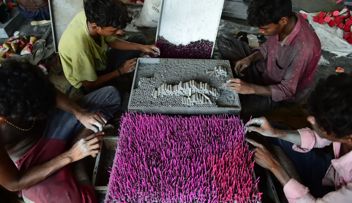 Pekerja membuat petasan di bengkel jelang festival Diwali di pinggiran Ahmedabad, India (21/9/2022). Festival ini melambangkan kemenangan baik atas keburukan, dan lampu atau pelita dinyalakan sebagai tanda perayaan serta harapan umat manusia. (AFP/Sam Panthaky)