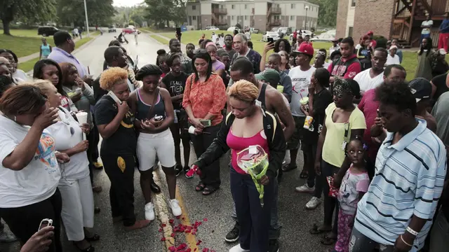 Lezley McSpadden (tengah) menaburkan bunga di lokasi kematian putranya, Michael Brown. (Huy Mach/St. Louis Post-Dispatch via AP)