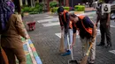 Sejumlah warga yang terjaring dalam razia penggunaan masker dihukum menyapu di Kelurahan Cimone, Kota Tangerang, Banten, Rabu (15/7/2020). Pemerintah Kota Tangerang memberlakukan sanksi sosial kepada pelanggar PSBB. (Liputan6.com/Angga Yuniar)
